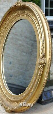 French Antique Louis XVI oval gilt frame mirror, gold leaf on carved wood